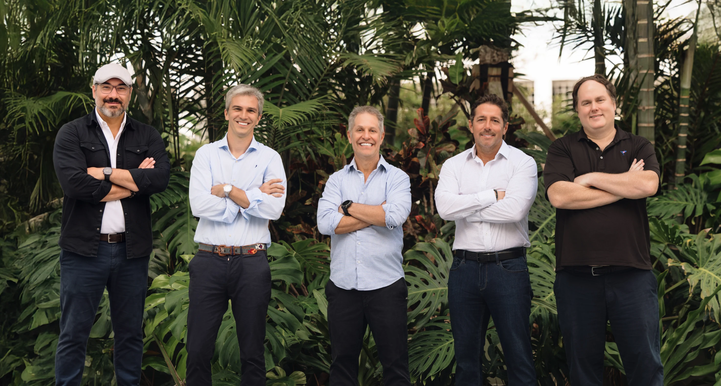 The five HelloGov and iVisa founders standing together in front of tropical plants
