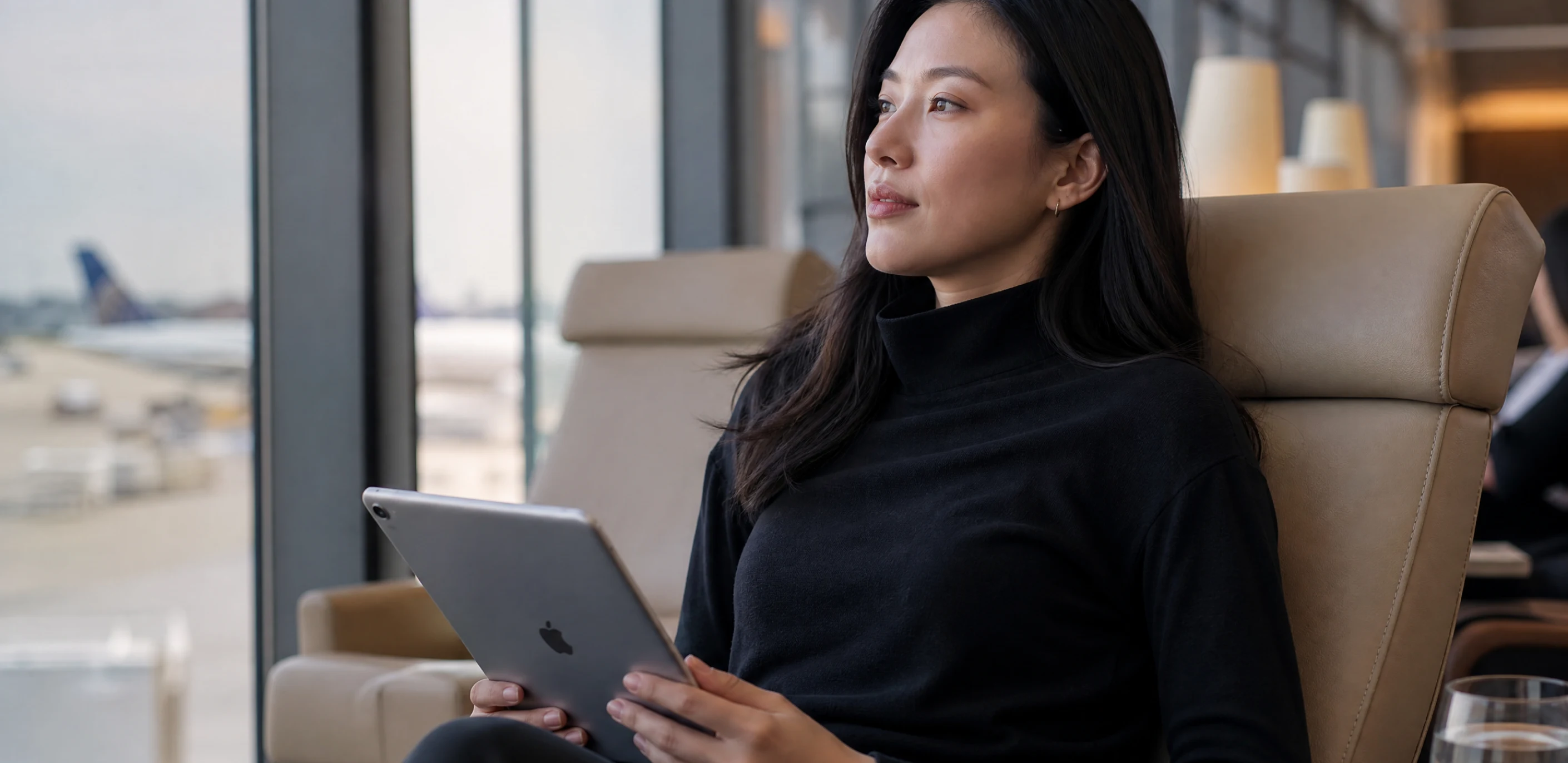 A traveler with a tablet relaxing in an airport lounge